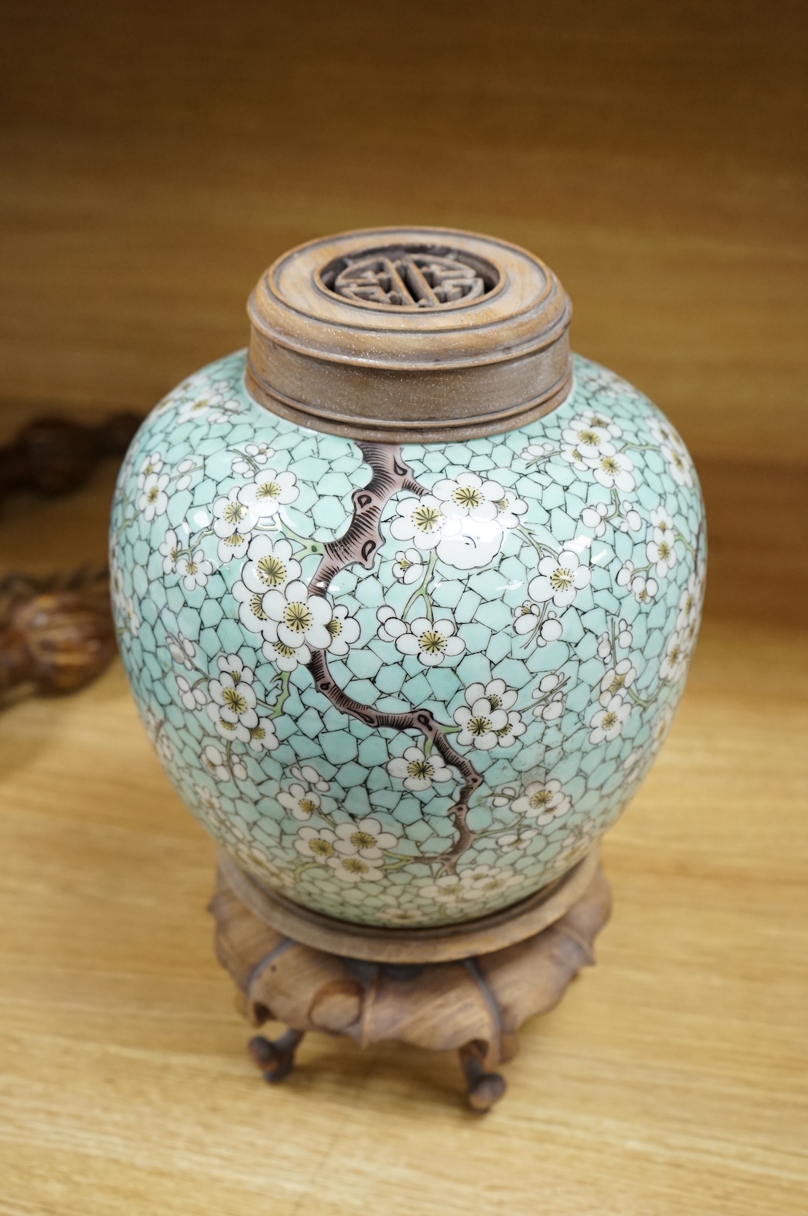 A Chinese famille verte enamelled prunus jar, 19th century, with wood cover and stand, 25cm high